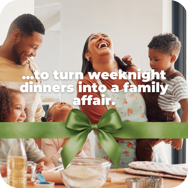 Happy family of five laughing together as they make dinner. Green holiday bow graphic treatment across image.