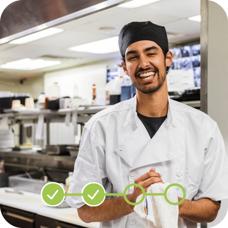Youthful culinary professional working in a commercial kitchen representing workforce outcomes of structured career pathway programs.